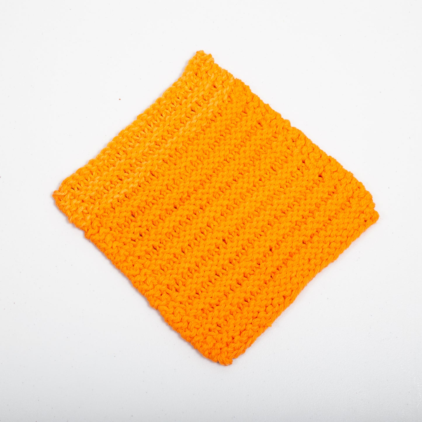 Three orange cotton wash cloths laid out on a white background.